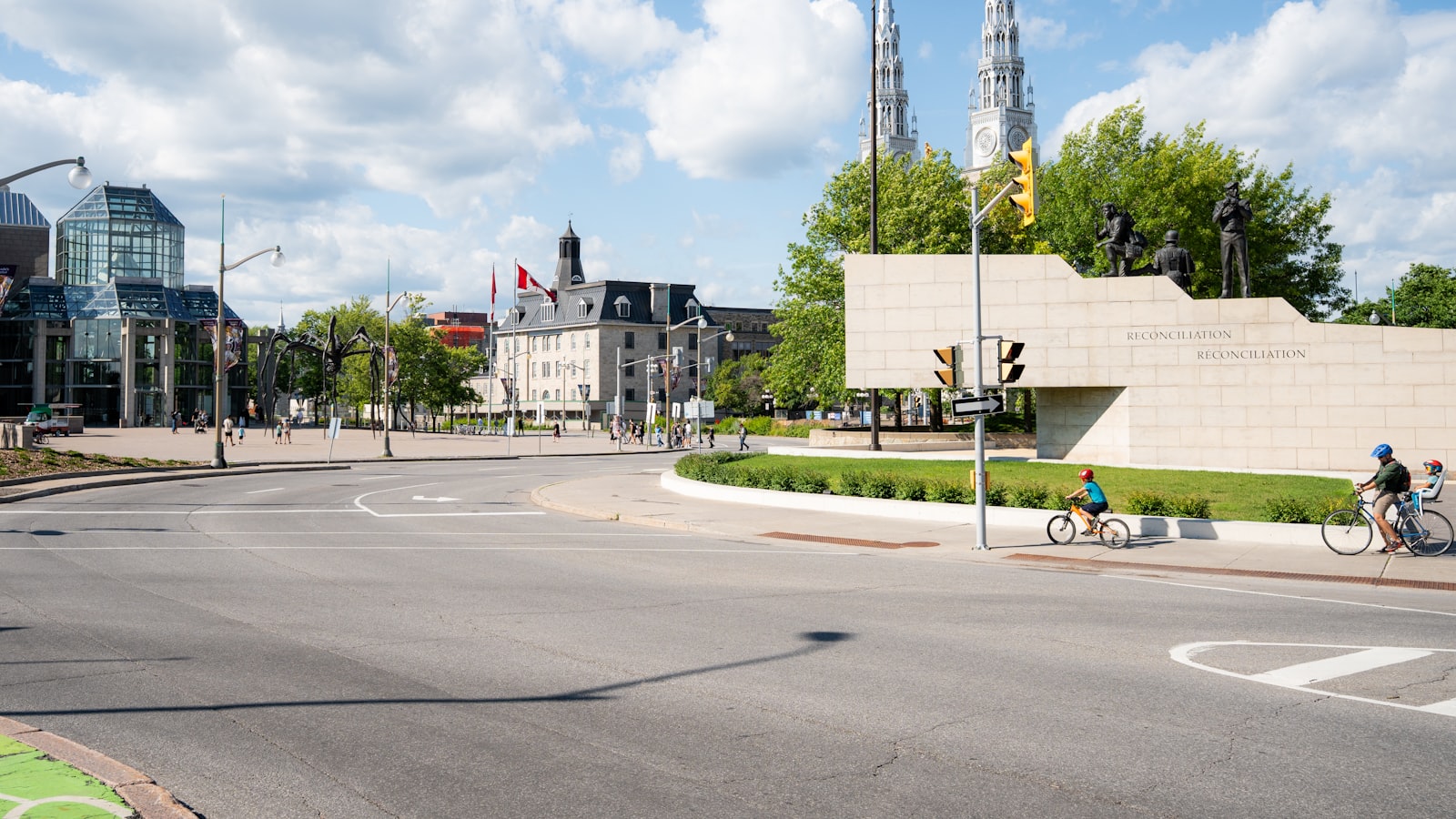 Street scene with cyclists, a Reconciliation monument, and the National Gallery of Canada in the distance