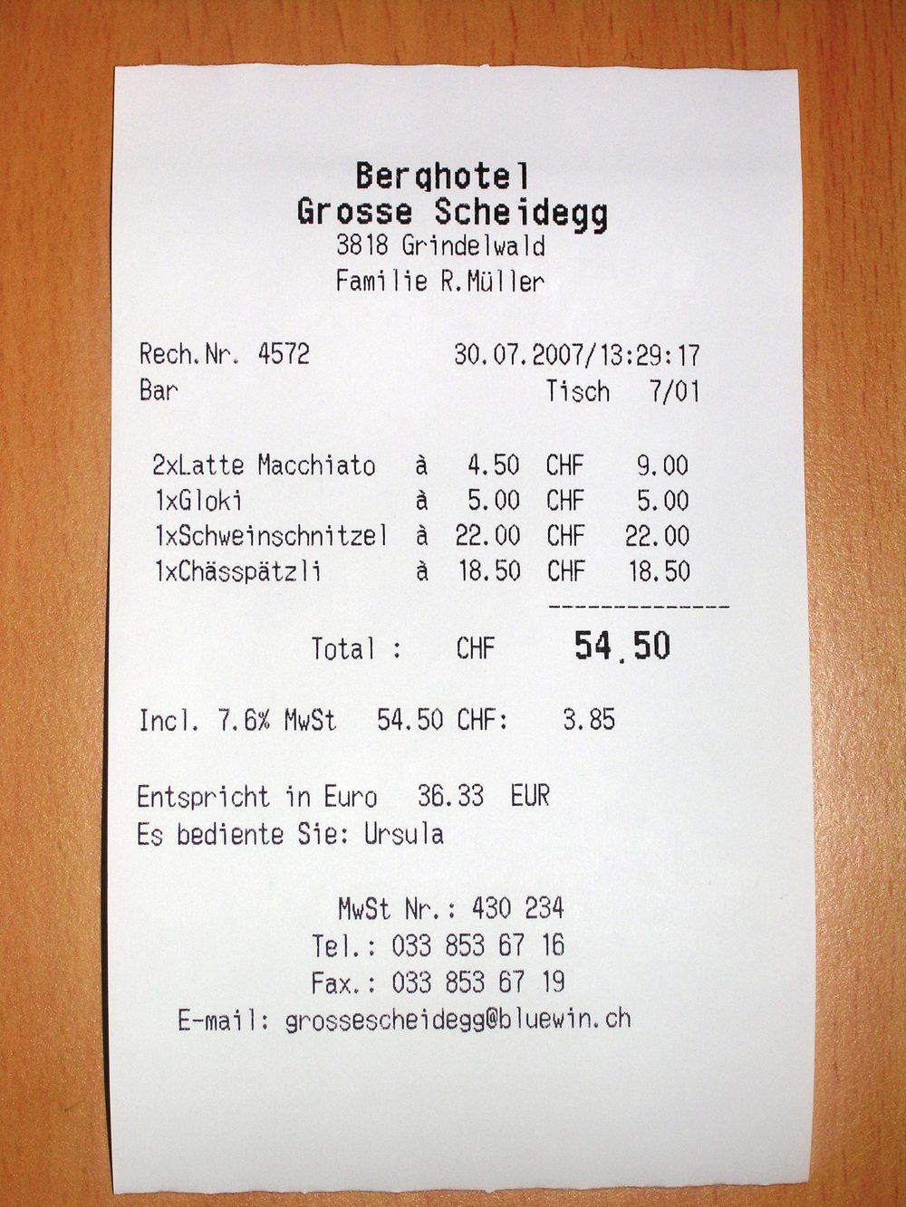 A photograph of a printed receipt resting on a wooden surface