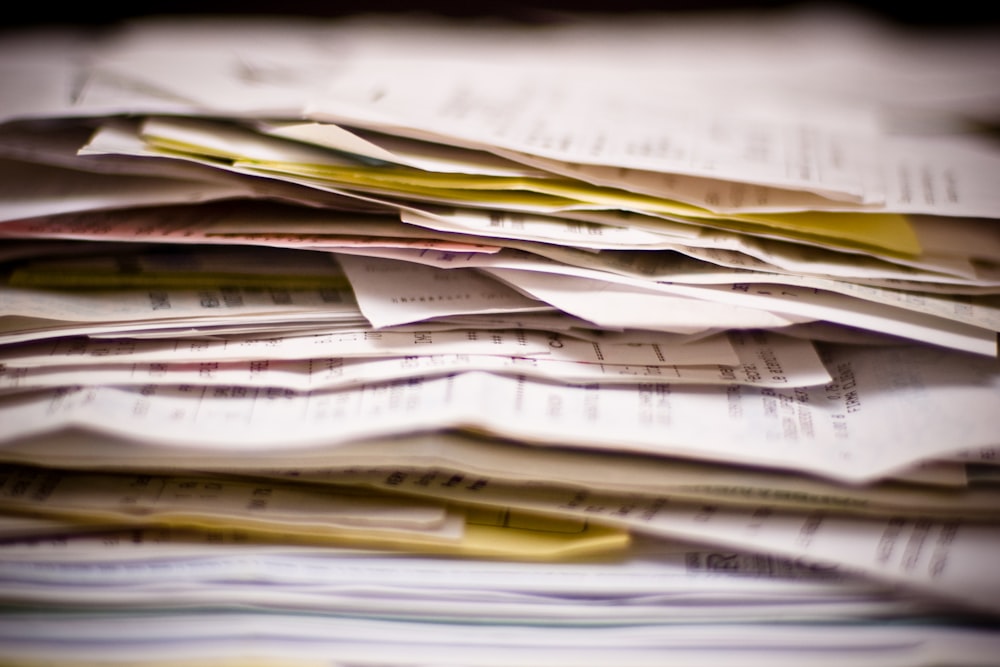 A close-up view of a large, messy stack of white paper receipts