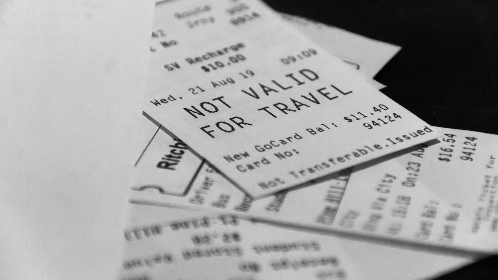 A black and white photograph of several receipts overlapping, with one reading NOT VALID FOR TRAVEL
