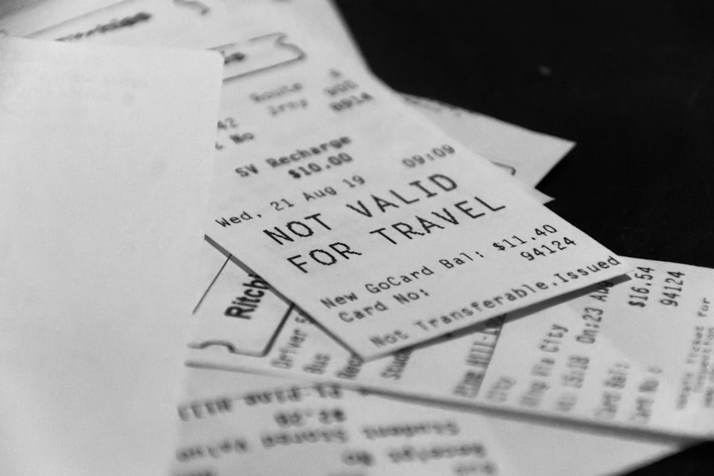A black-and-white photograph shows a pile of printed paper tickets and receipts