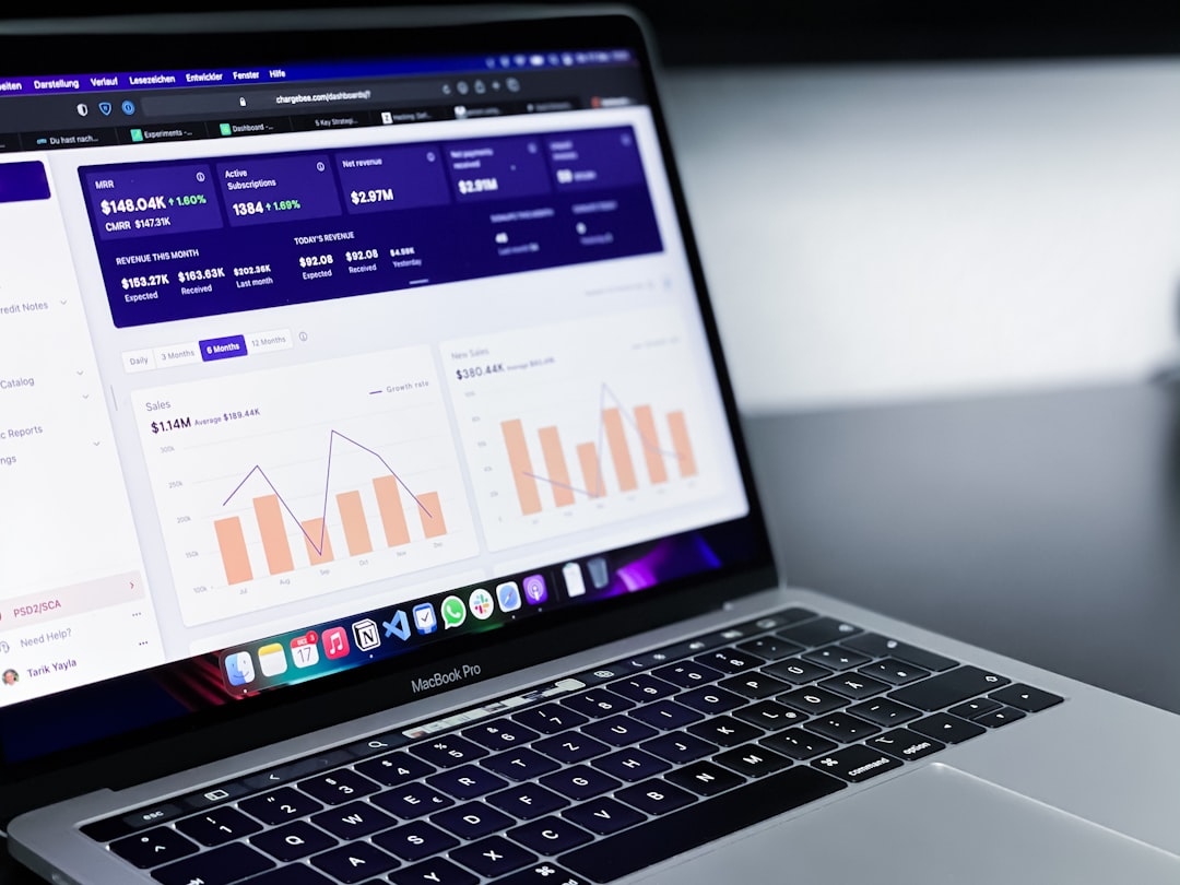A laptop displays a dashboard with charts and graphs